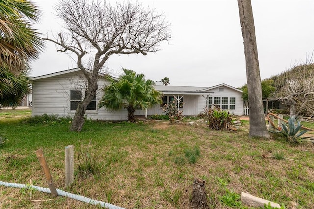 rear view of property featuring a yard