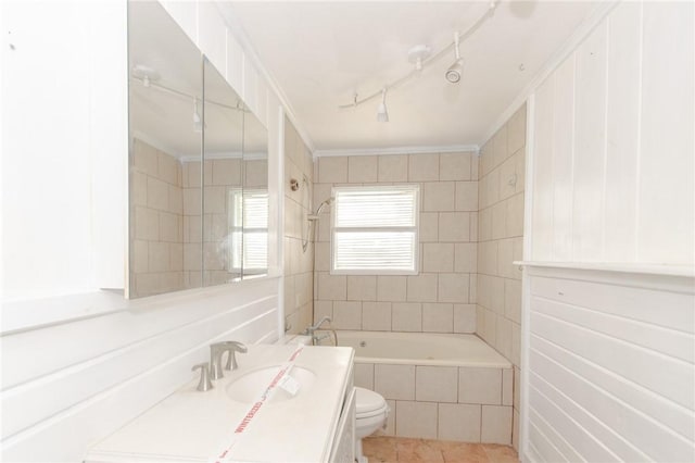 full bathroom featuring tiled shower / bath combo, ornamental molding, vanity, toilet, and tile patterned floors