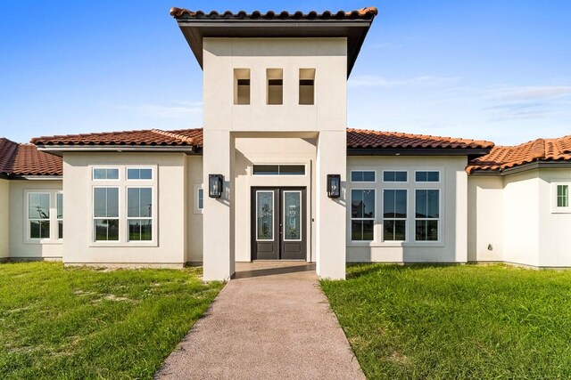 6 La Buena Vida Dr, Aransas Pass, TX 78336 - back of house featuring stucco siding, french doors, a yard, and a tiled roof