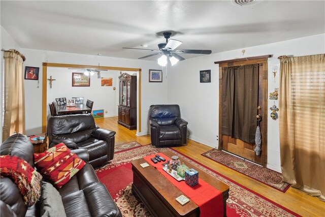 living room featuring light wood-type flooring and ceiling fan