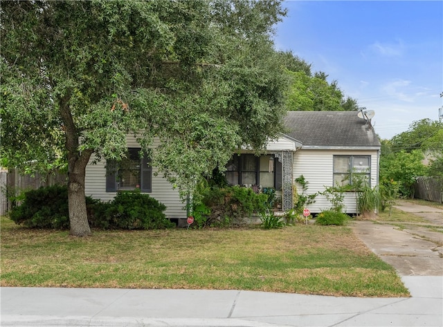 view of property hidden behind natural elements with a front lawn