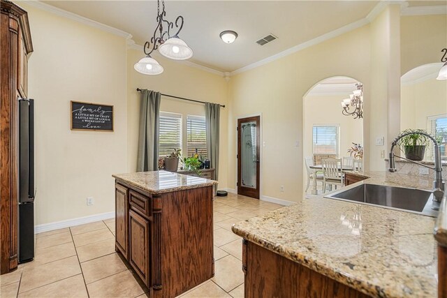 11330 Brendel, Corpus Christi, TX 78410 - kitchen with arched walkways, a center island, ornamental molding, freestanding refrigerator, and a chandelier