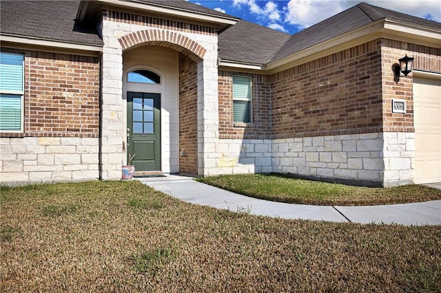 view of exterior entry featuring a yard