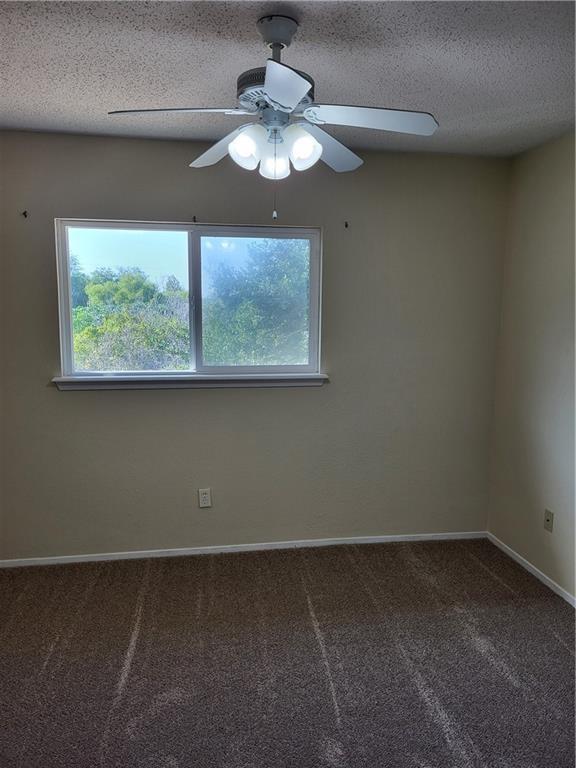 2213 Alazan Dr, Corpus Christi, TX 78418 - unfurnished room with carpet floors, ceiling fan, baseboards, and a textured ceiling
