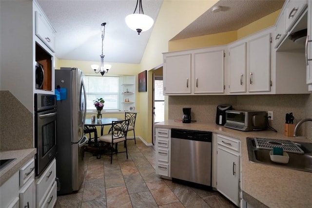 2213 Alazan Dr, Corpus Christi, TX 78418 - kitchen featuring stainless steel appliances, a sink, light countertops, white cabinetry, and vaulted ceiling