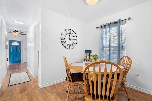 dining space with wood finished floors and baseboards