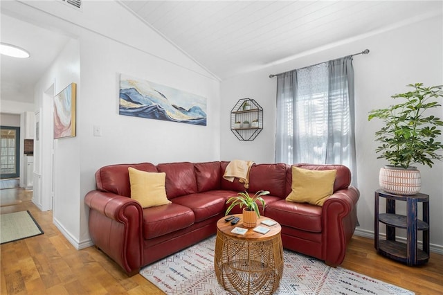 living room with lofted ceiling, baseboards, and wood finished floors