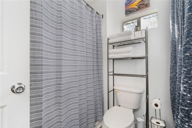 bathroom featuring a shower with shower curtain and toilet