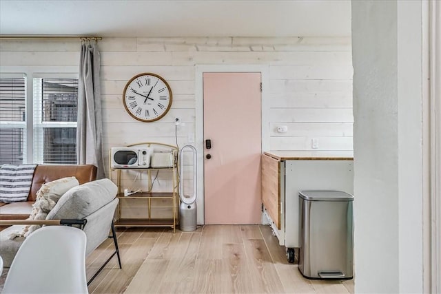 interior space featuring wooden walls and light hardwood / wood-style flooring