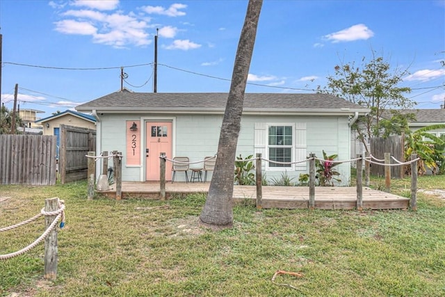 view of front of house with a wooden deck and a front lawn