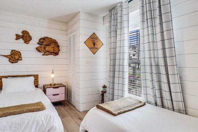 bedroom featuring multiple windows and wooden walls