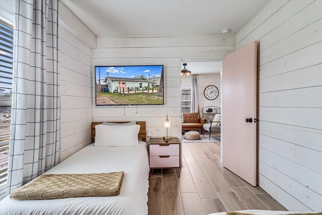 bedroom featuring hardwood / wood-style floors and wood walls