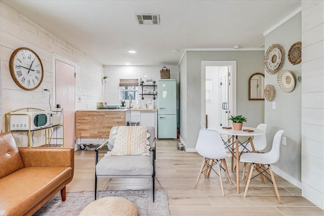 living room with ornamental molding, a wealth of natural light, and light wood-type flooring