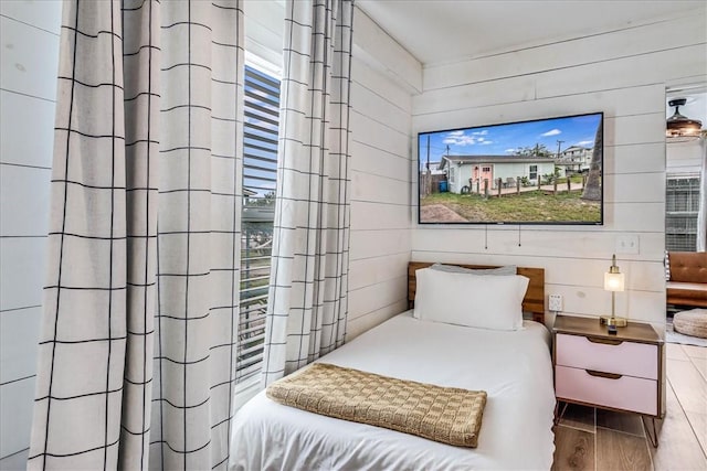 bedroom featuring wooden walls