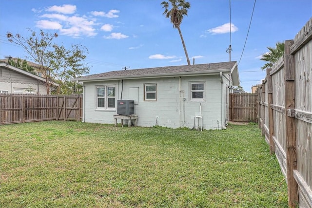 back of house featuring central AC and a lawn