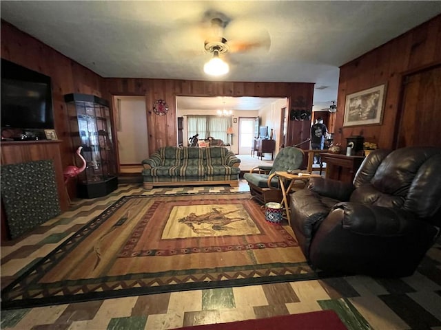 living room with a chandelier and wood walls