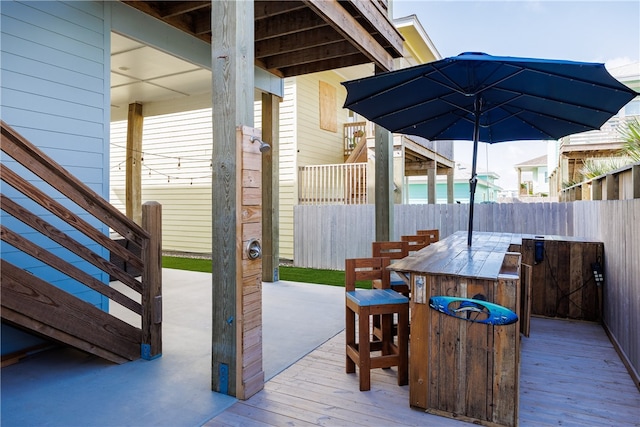 wooden terrace with an outdoor bar and a patio area