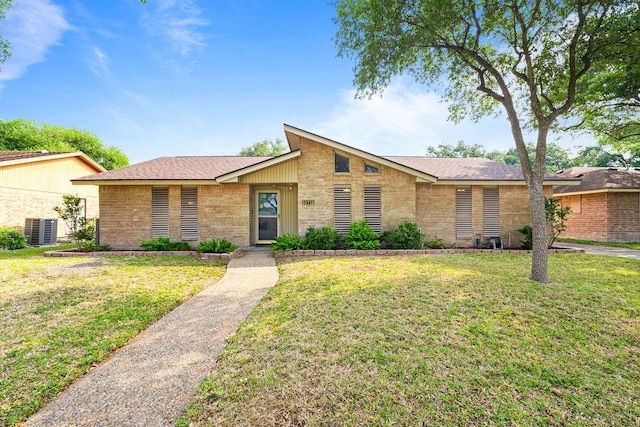 10710 Atlanta St, Corpus Christi, TX 78410 - mid-century modern home featuring central AC, a front lawn, and brick siding