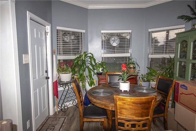 dining space with crown molding and wood finished floors