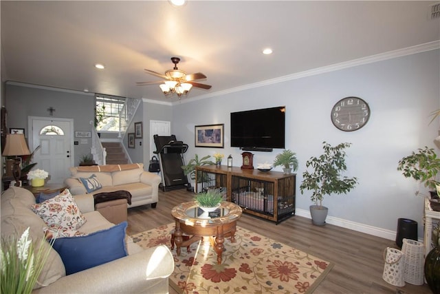 living room with stairway, wood finished floors, and ornamental molding