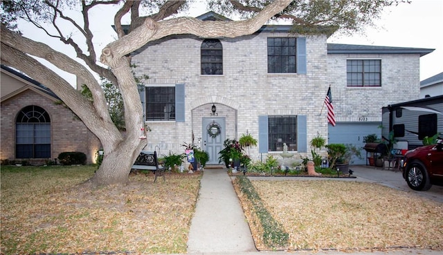 view of front of house with a front lawn, brick siding, concrete driveway, and an attached garage