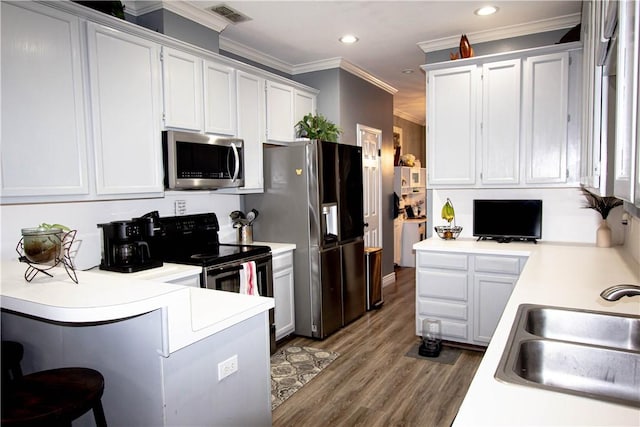 kitchen featuring visible vents, light countertops, a peninsula, stainless steel appliances, and a sink