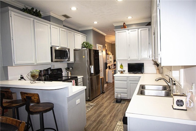 kitchen featuring visible vents, a peninsula, a sink, stainless steel appliances, and crown molding