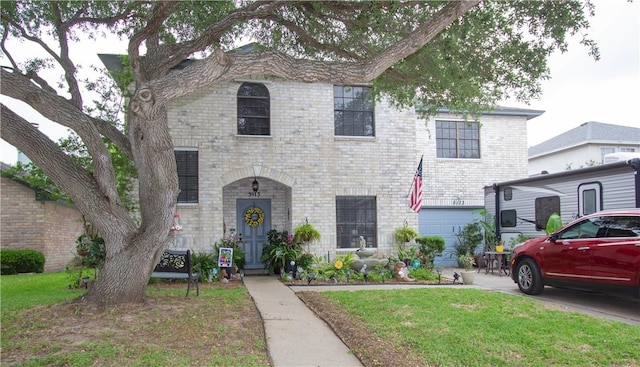 5113 Queens Ct, Corpus Christi, TX 78413 - view of front facade with an attached garage, brick siding, and a front lawn