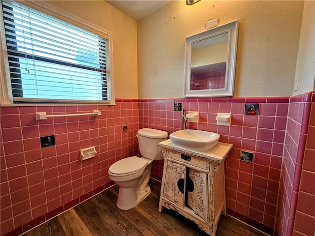 515 Deforrest St, Corpus Christi, TX 78404 - half bath featuring wood finished floors, vanity, a wainscoted wall, and tile walls