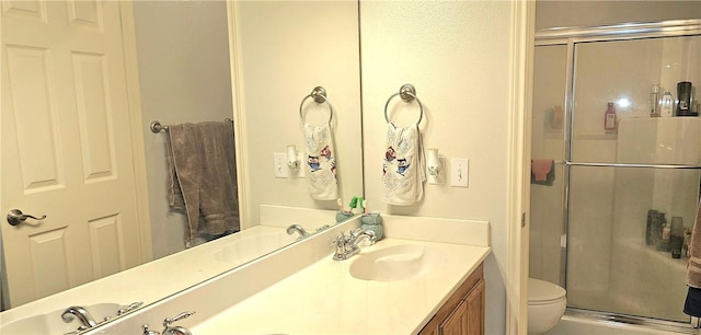 bathroom featuring toilet, vanity, and walk in shower