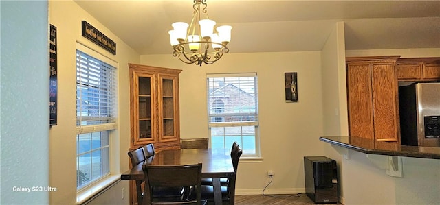 dining space with wood-type flooring and a chandelier