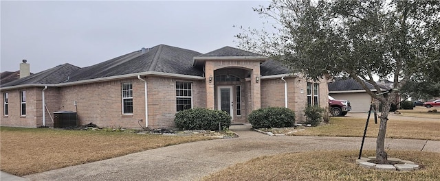 ranch-style house with a garage, central AC, and a front lawn