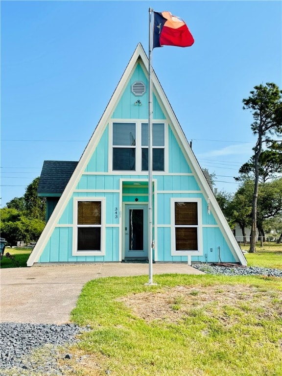 343 Bracht, Rockport, TX 78382 - a-frame home featuring board and batten siding, a front yard, and a shingled roof