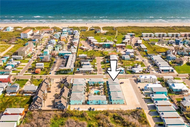 birds eye view of property featuring a water view and a beach view