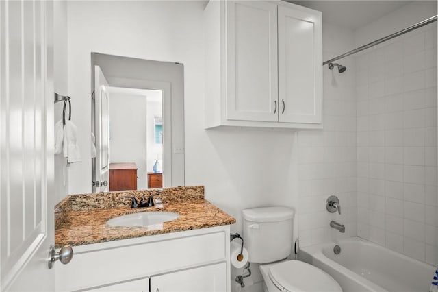 full bathroom featuring vanity, tiled shower / bath combo, and toilet