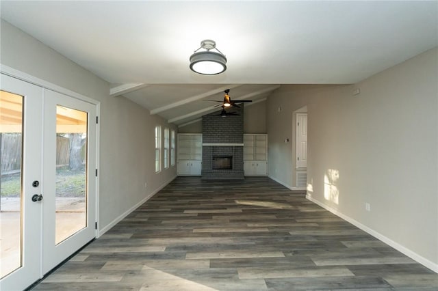 unfurnished living room featuring ceiling fan, french doors, dark wood-type flooring, vaulted ceiling with beams, and a fireplace