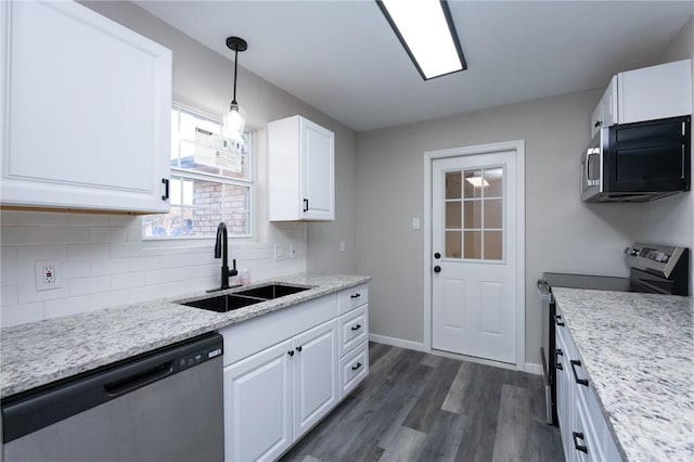 kitchen featuring light stone countertops, stainless steel appliances, sink, white cabinets, and hanging light fixtures