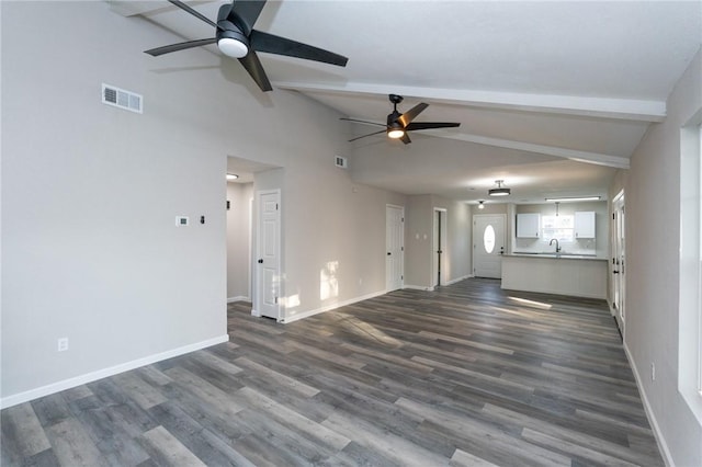 unfurnished living room with vaulted ceiling with beams, ceiling fan, and dark hardwood / wood-style flooring