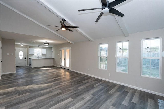 unfurnished living room featuring ceiling fan, dark wood-type flooring, lofted ceiling with beams, and sink