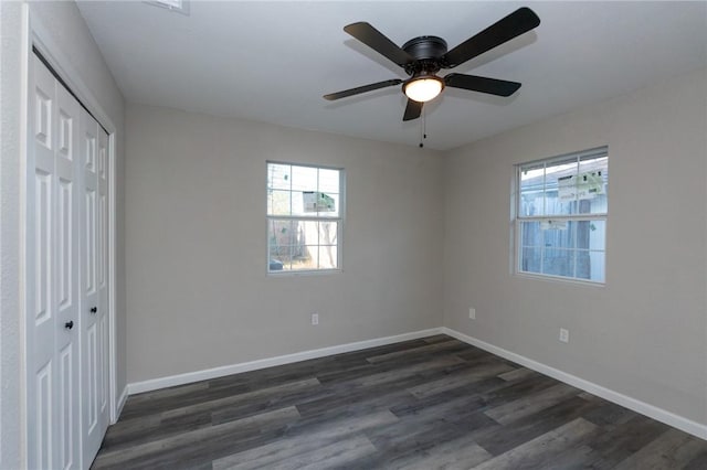 unfurnished bedroom with ceiling fan, dark hardwood / wood-style floors, and a closet