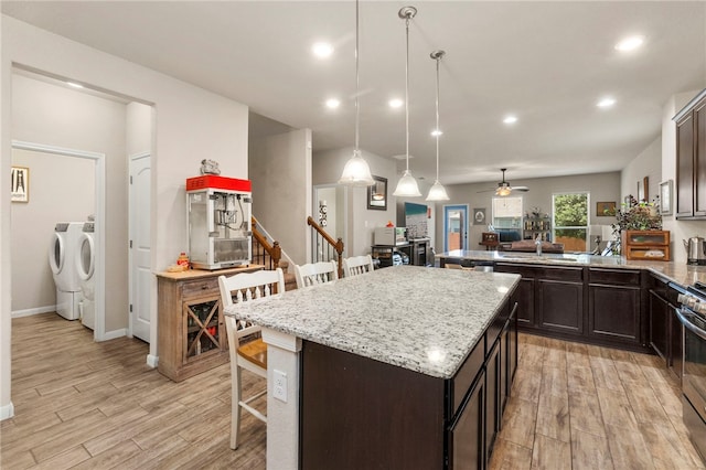 10343 Rosalina Loop, Converse, TX 78109 - kitchen featuring independent washer and dryer, a kitchen breakfast bar, light wood-style flooring, dark brown cabinetry, and recessed lighting