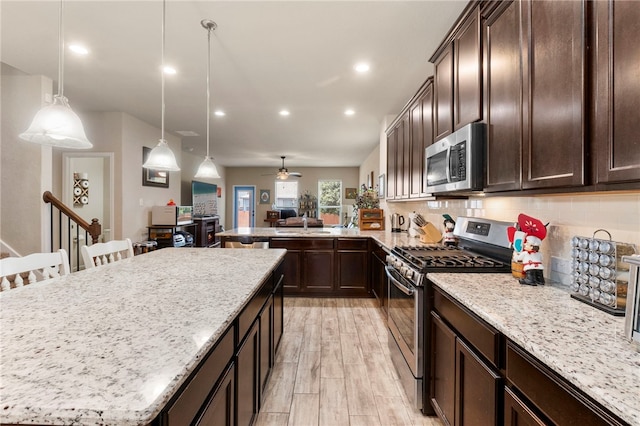 10343 Rosalina Loop, Converse, TX 78109 - kitchen featuring appliances with stainless steel finishes, a center island, dark brown cabinets, and recessed lighting