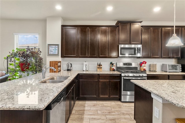 10343 Rosalina Loop, Converse, TX 78109 - kitchen featuring appliances with stainless steel finishes, dark brown cabinetry, light stone counters, a peninsula, and recessed lighting