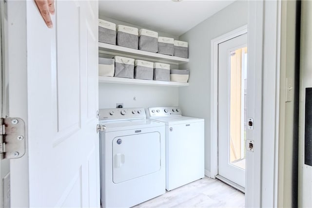laundry room featuring washing machine and dryer and light wood-type flooring