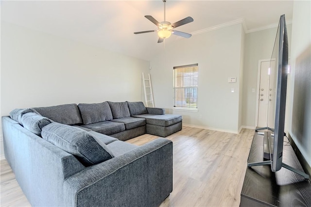 living area featuring light wood-type flooring, a ceiling fan, baseboards, ornamental molding, and vaulted ceiling
