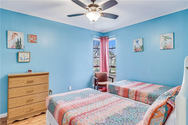 bedroom with wood finished floors, a ceiling fan, and crown molding