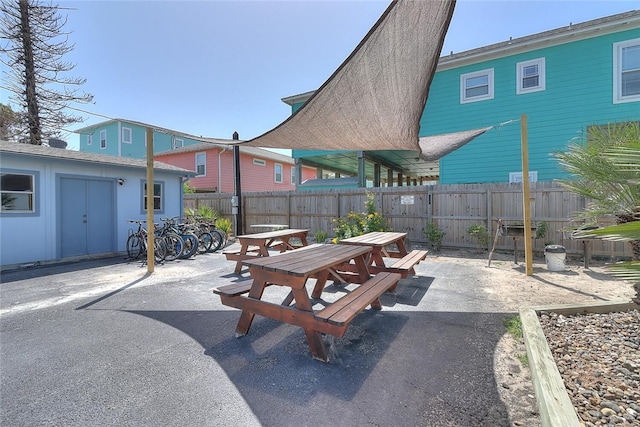 view of patio / terrace featuring outdoor dining space, fence, and an outdoor structure