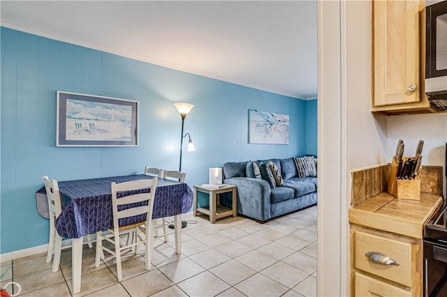 living area featuring crown molding and light tile patterned floors