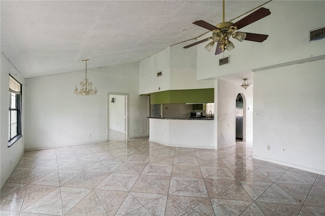 unfurnished room featuring ceiling fan with notable chandelier, a textured ceiling, and high vaulted ceiling