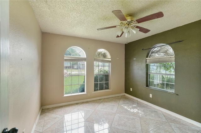 tiled spare room featuring ceiling fan and a textured ceiling